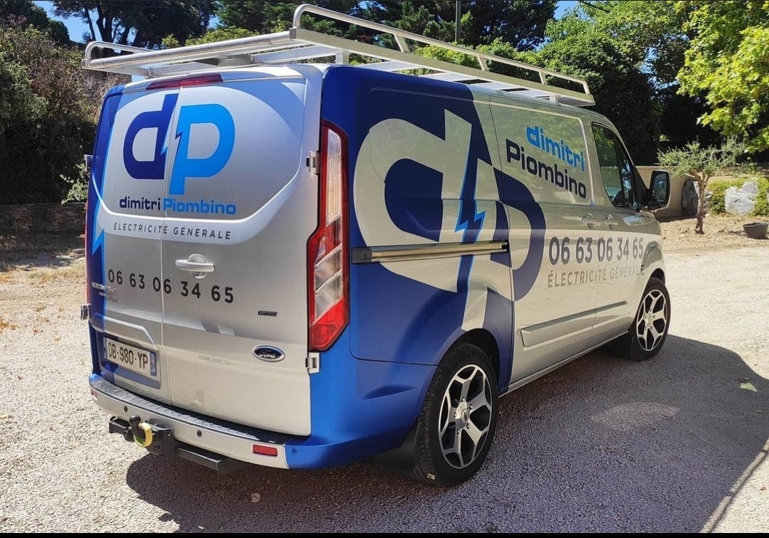 Van Ford Transit Custom argenté de Dimitri Piombino, électricien général, avec logo dP, numéro 06 63 06 34 65 et rack de toit.